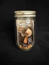 Load image into Gallery viewer, Small glass jar with metallic lid containing various items on a black background