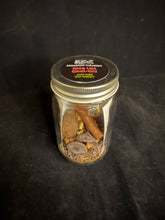 Load image into Gallery viewer, Small glass jar with a metal lid containing chocolate, chai, and a cinnamon stick on a dark background
